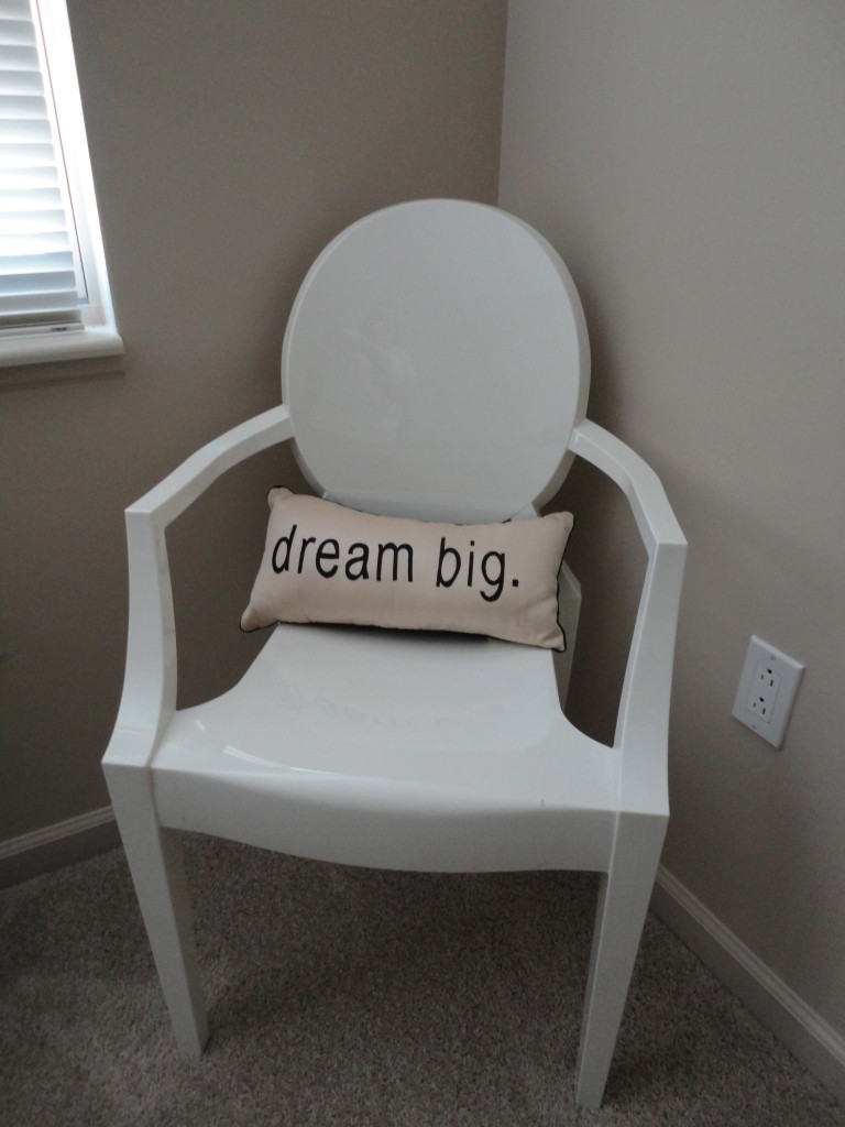 Louis Ghost chair in white with a dream big pillow resting on it in the corner of a bedroom