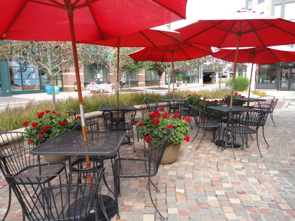 Cafe tables with umbrellas everywhere for residents and guests to enjoy and use