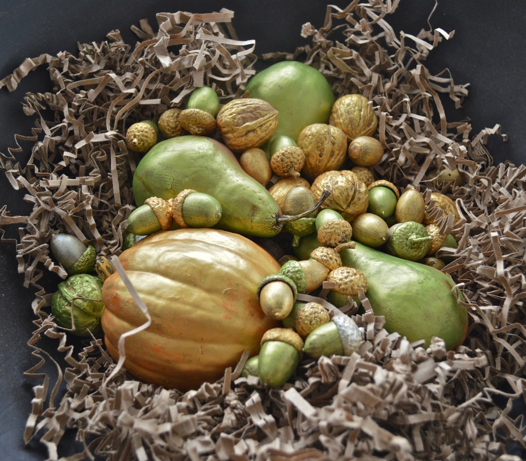 Gilded nuts and fruit nestled in a wooden bowl.