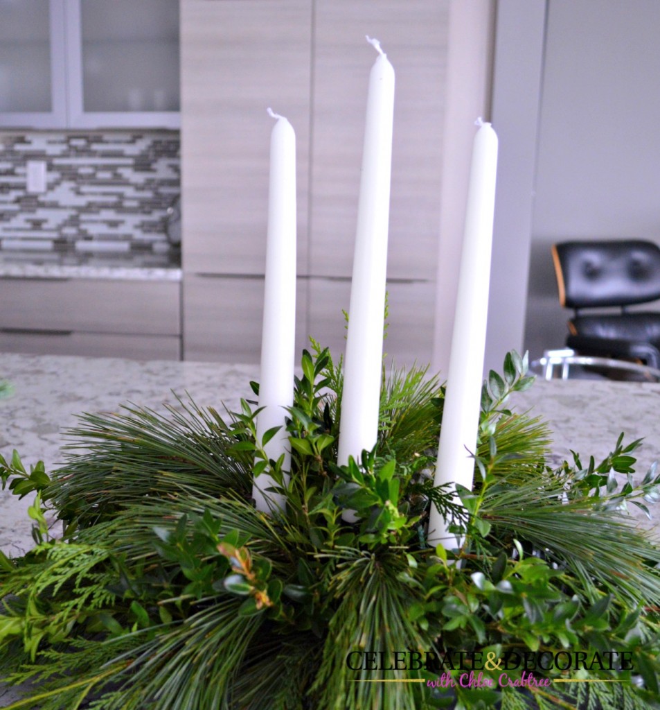 Three candles in an evergreen centerpiece