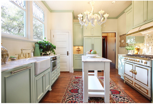 Pale painted cabinets with a farmhouse sink and a narrow island.