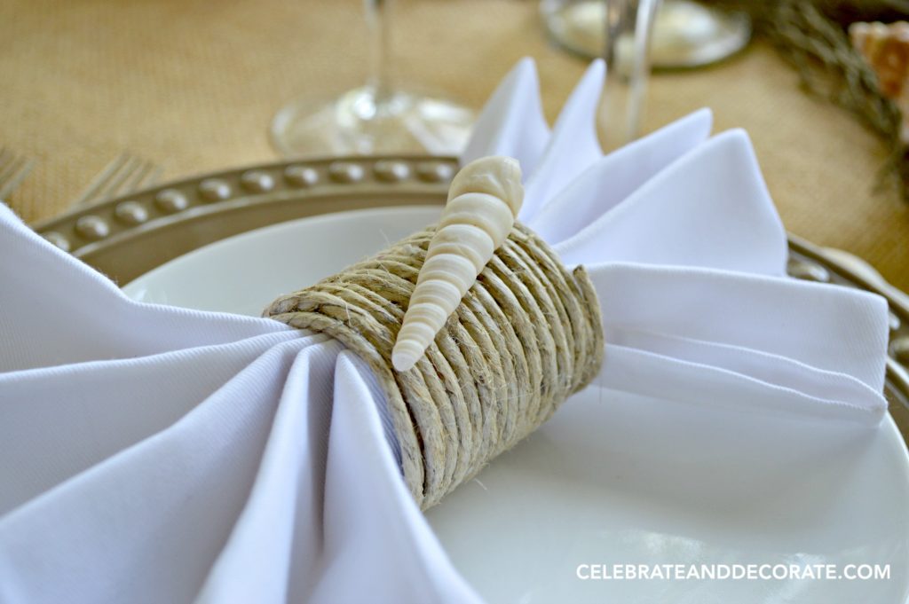 A close up of a seashell trimmed napkin ring.  