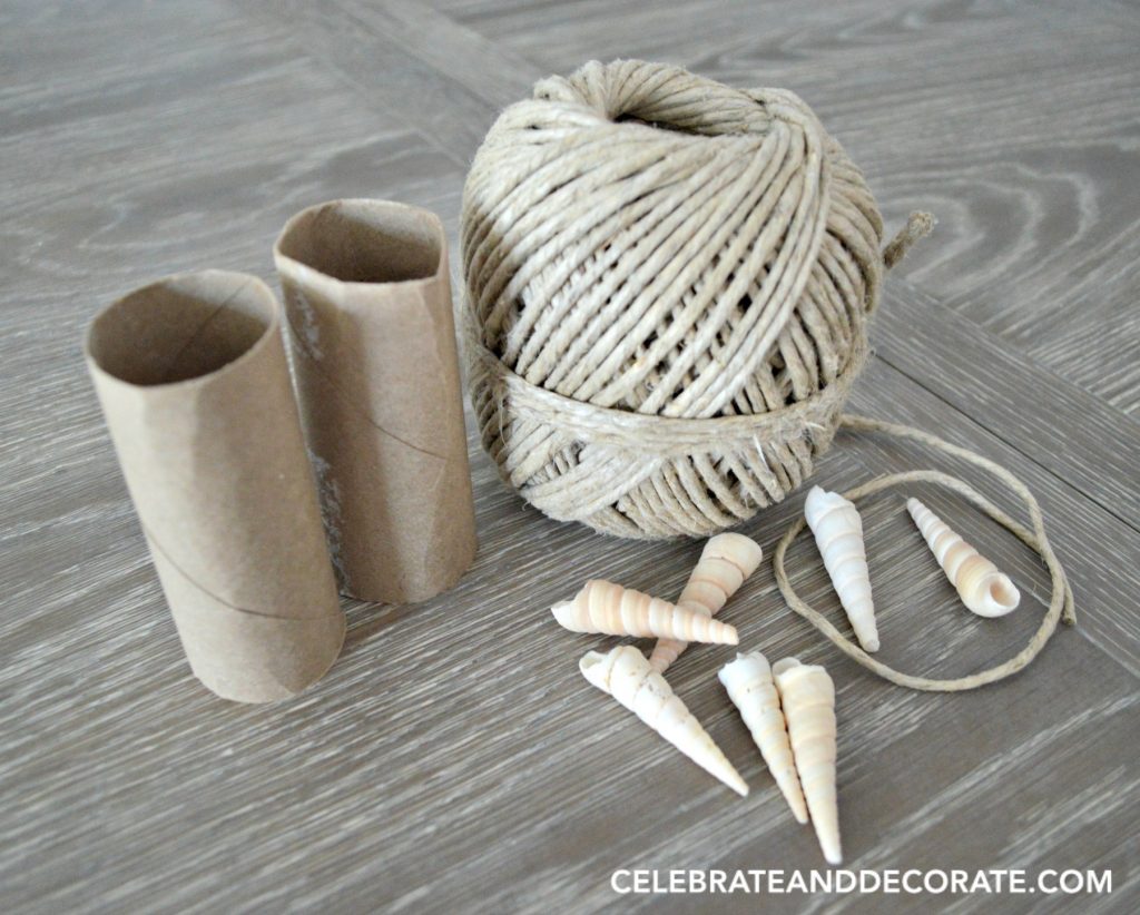 Hemp twine, cardboard tubes and seashells on a wooden tabletop