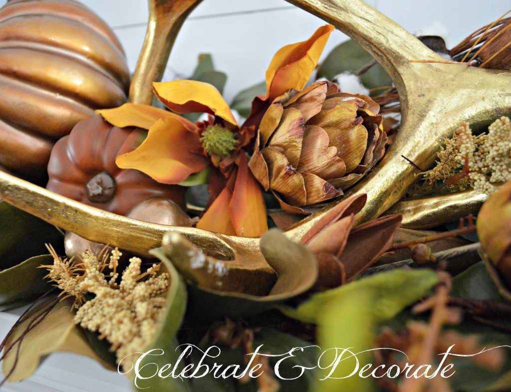 Dried magnolia blossoms and dried artichokes are nestled amongst the antlers and magnolias on this Fall mantel.