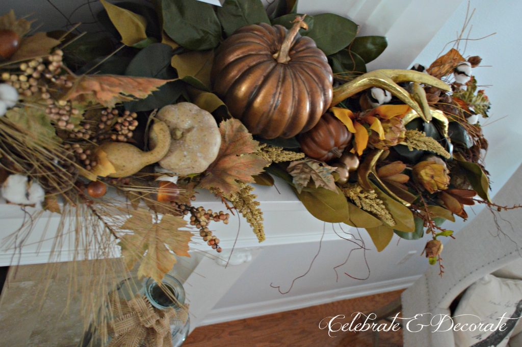 Magnolias, cotton bolls, gourds, pumpkins and antlers make for a lavish display on this Fall or Thanksgiving mantel.