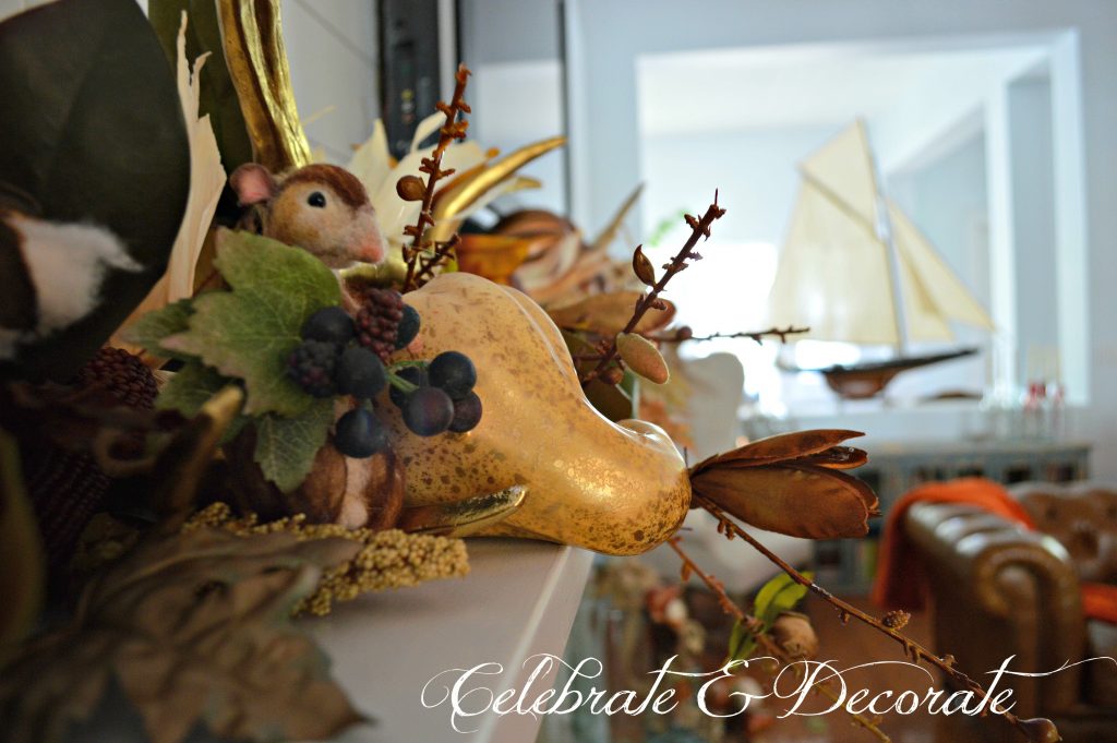 A tiny needled felted mouse peeks out among from the display on this stunning Fall mantel.