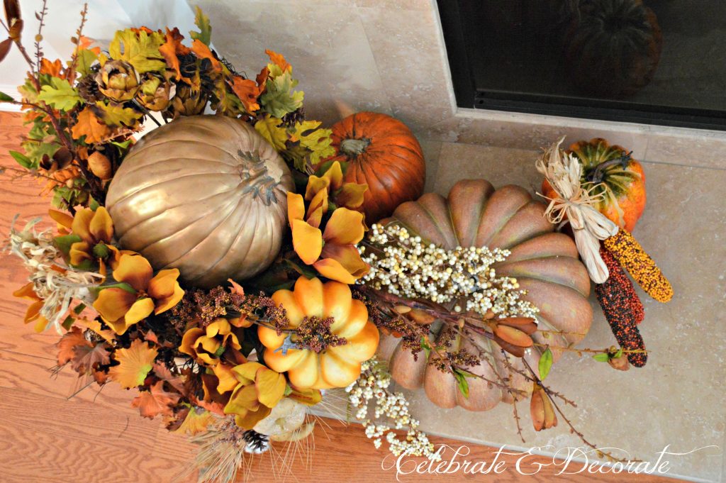 A splendid arrangement of leaves and pumpkins grace the hearth in this Thanksgiving display.