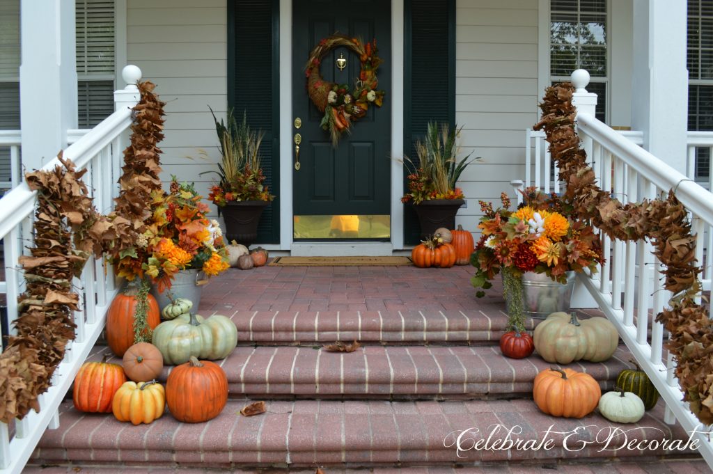 A lush front porch all decked out for Fall with Fall florals and pumpkins