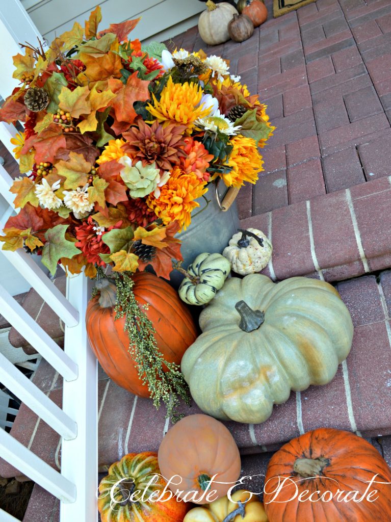 For a farmhouse feel to your front porch fill galvanized tubs or bushel baskets with faux fall flowers