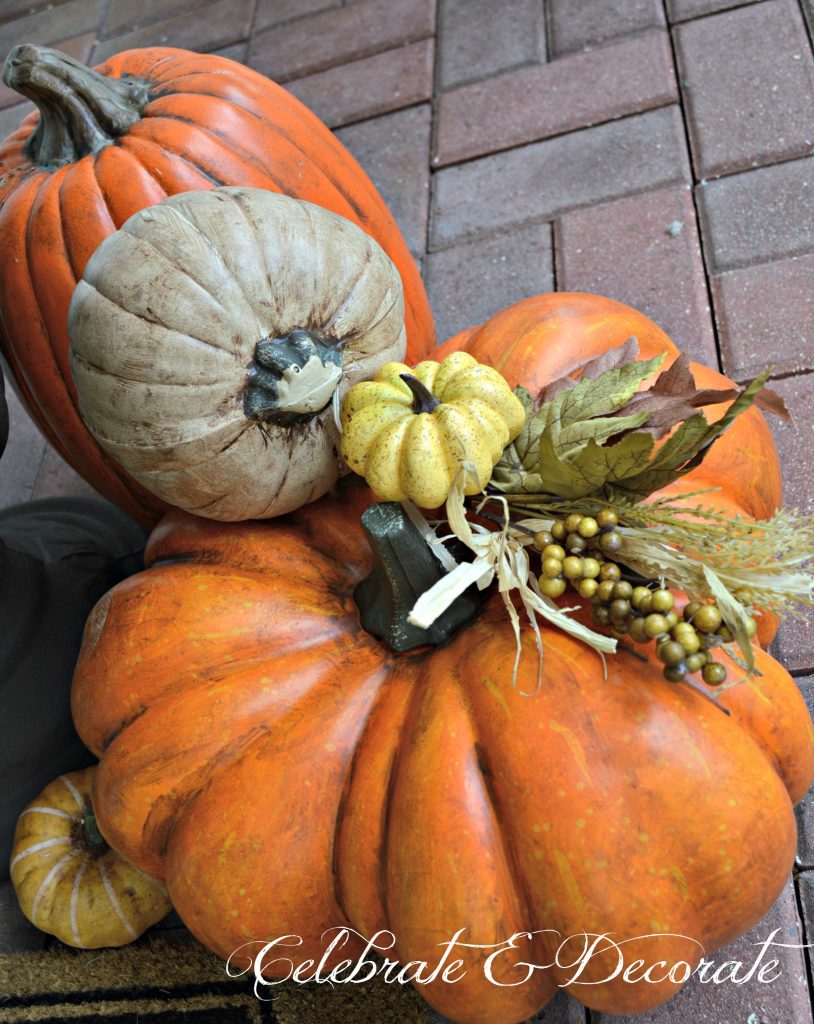 Enhance your faux pumpkins with a wash of acrylic paint and add a faux floral pick.
