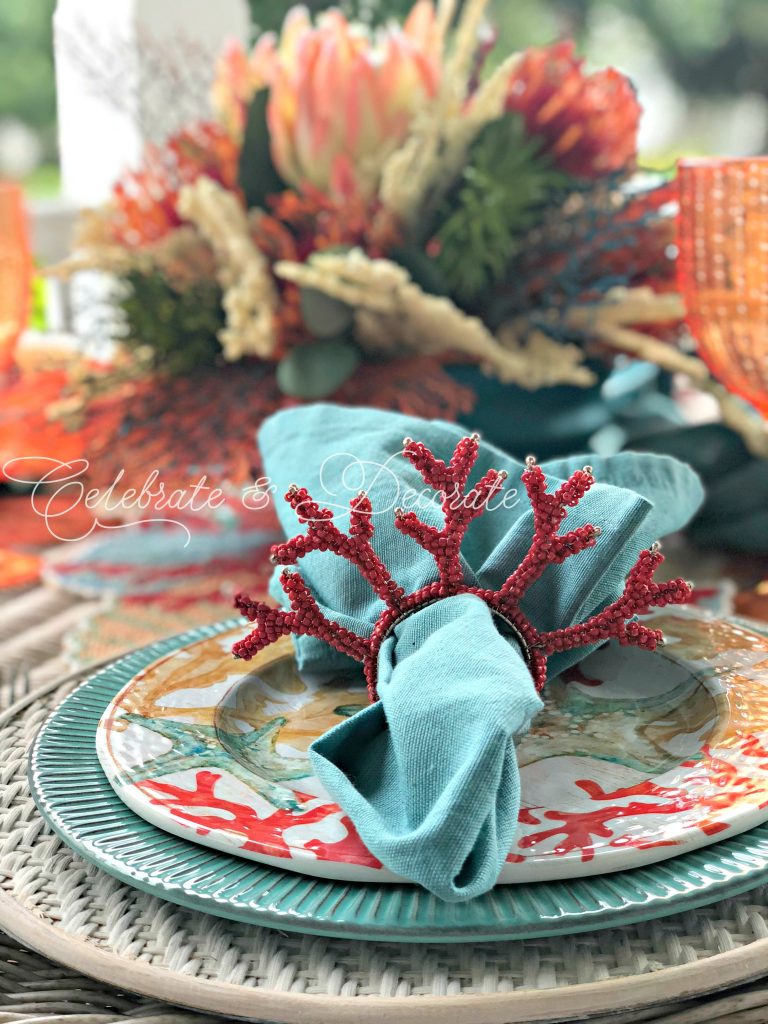 Beaded coral napkin rings help set the mood for a coastal dinner table.