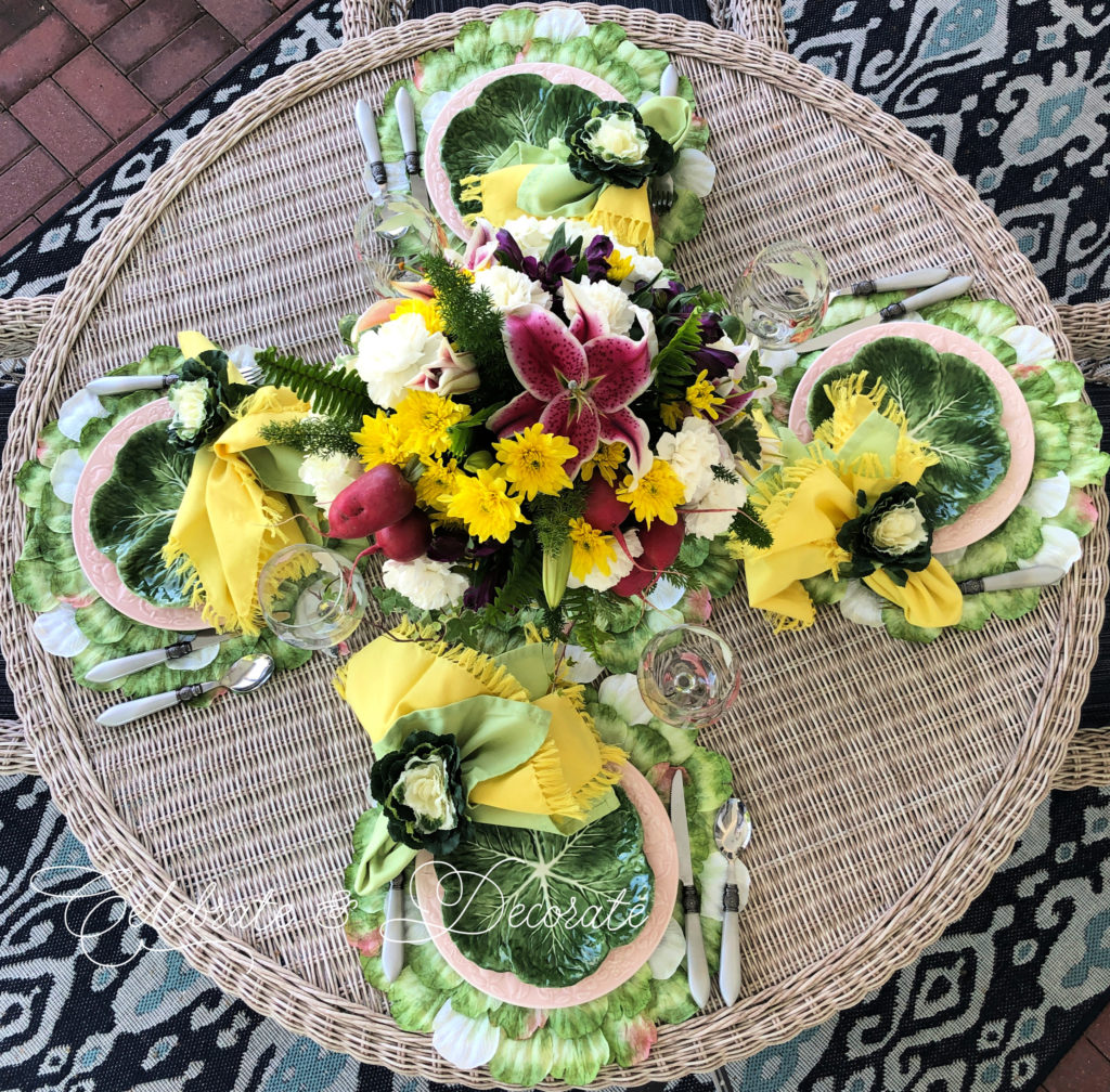 Floral centerpiece on table top with cabbage plates.