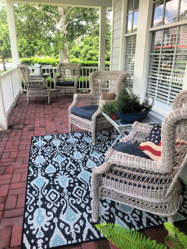 Front porch with comfy oversized chairs and shades of blue indoor/outdoor rugs