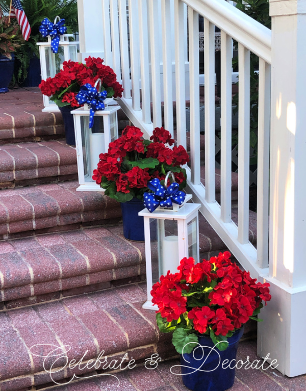 White lanterns and red geraniums decorate brick steps