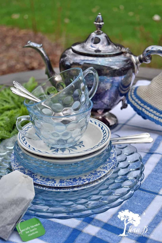 Stack of pretty blue plates and a silver tea pot.