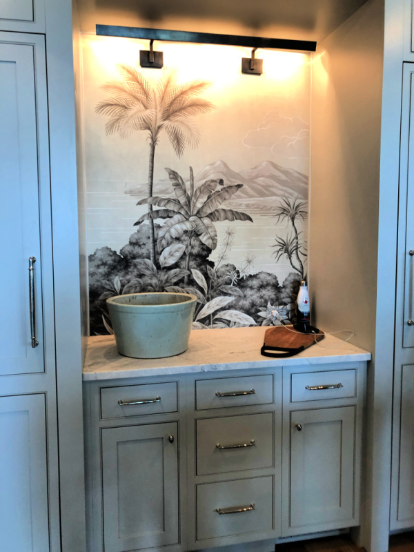 Kitchen counter with palm wallpaper behind it