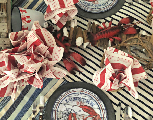 Overhead picture of a lobster themed dinner party place settings with plastic lobsters