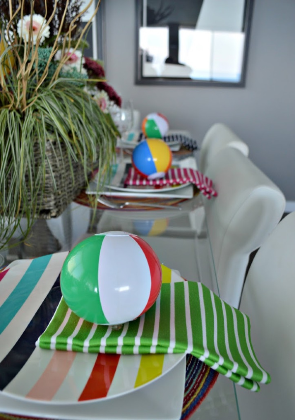 Table set with colorful striped plates and napkins and cute little beach balls