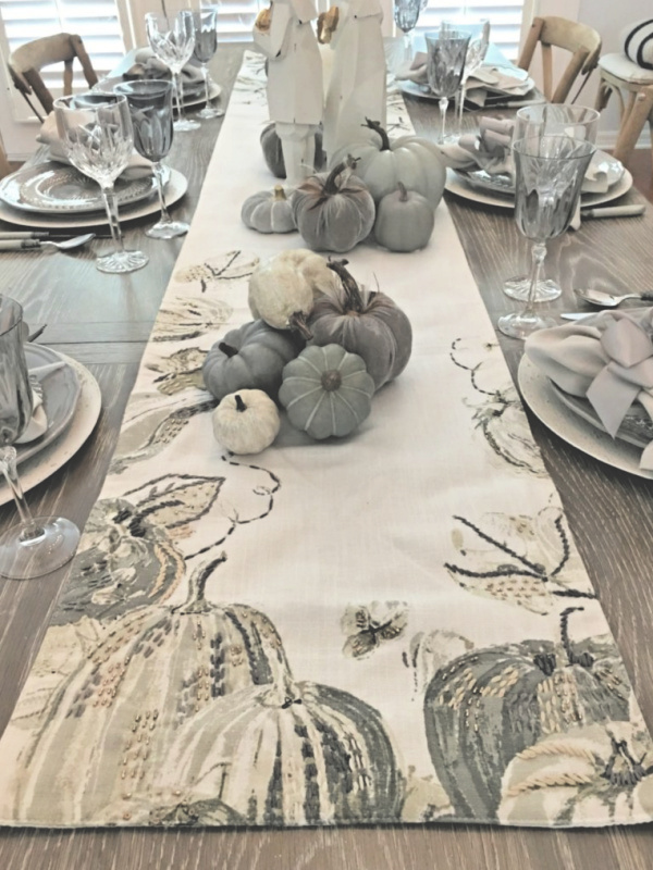 fall or thanksgiving table with elegant gray and white table runner and gray and white pumpkins and gray crystal goblets