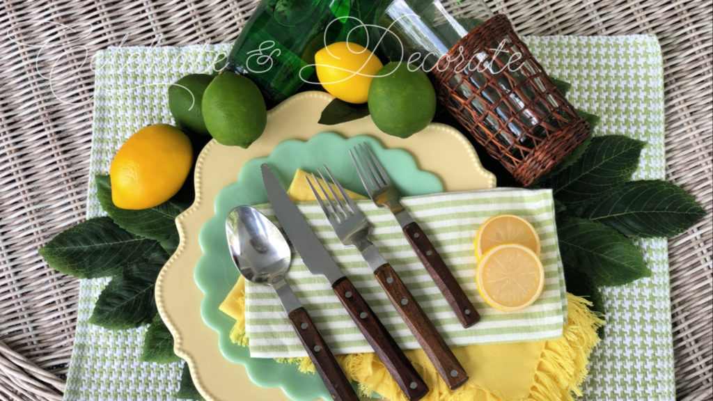A lemon lime tablescape with yellow Nicole Miller scalloped dinner plates, Pioneer woman jade green salad plates and Ikea wood handled flatware and green and white striped napkins
