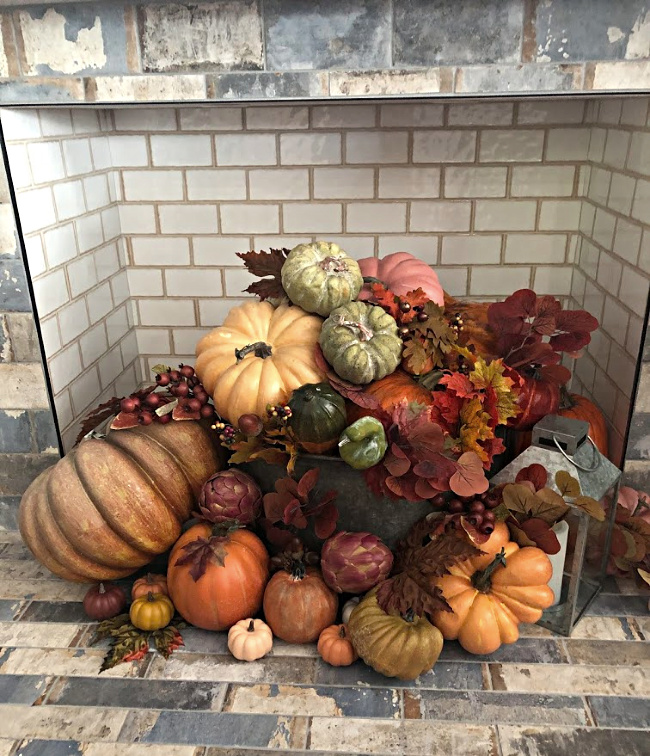 Hearth filled with and array of pumpkins and gourds and fall leaves for fall