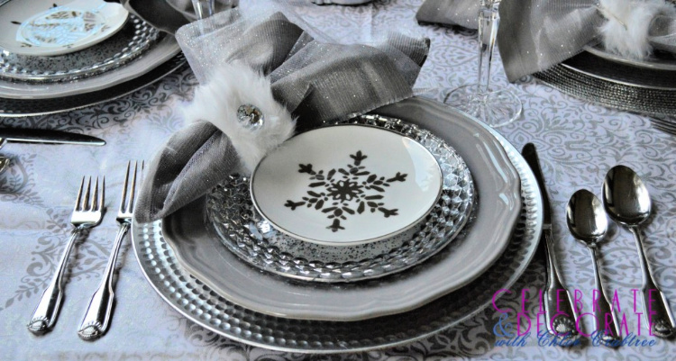 Gray, white and silver dishes with silver flatware adorn a winter tablesetting