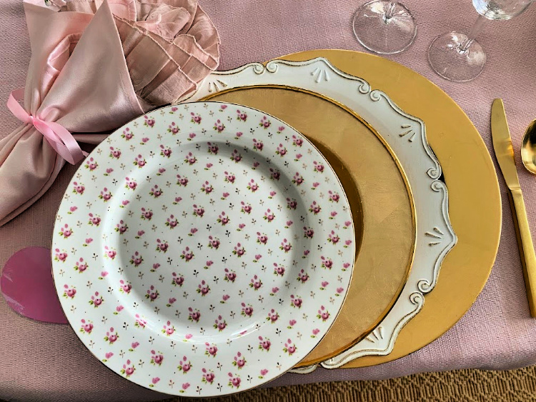 Floral plate, gold plates, white charger plates, gold charger plates and pink napkins