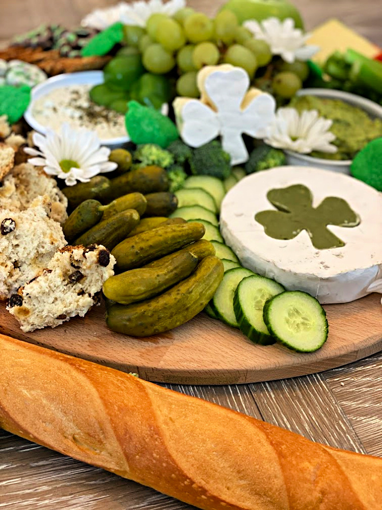 St. Patrick's Day grazing board with green foods and a shamrock shaped cheese