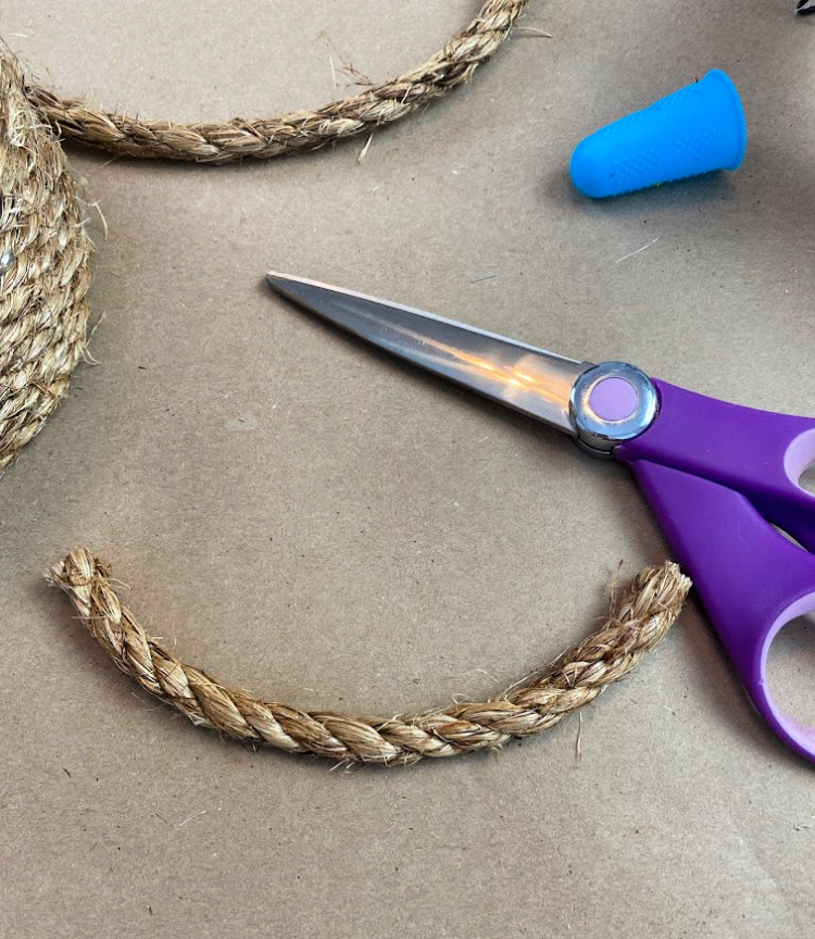 purple handled scissors, a piece of jute rope and a silicone finger protector