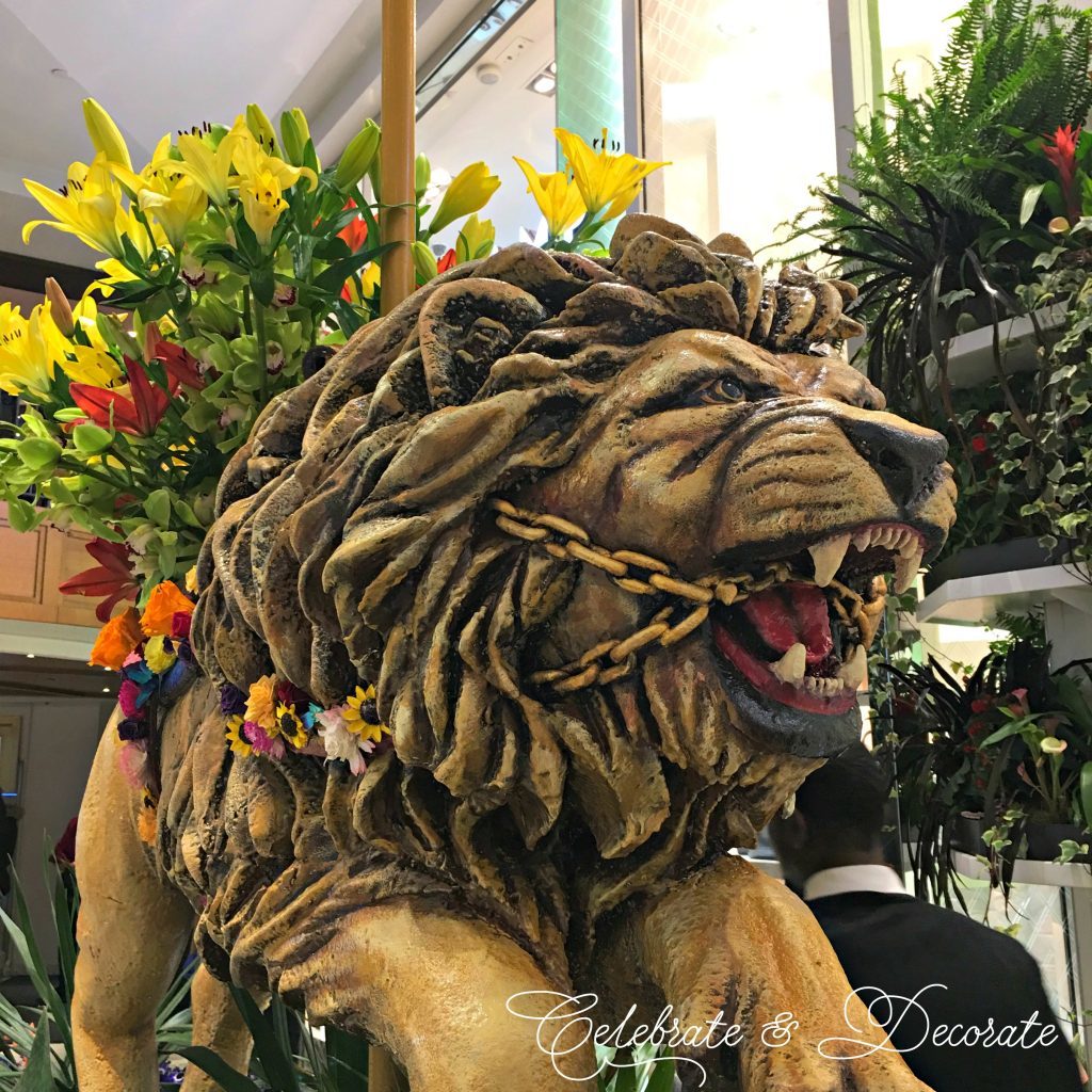 A lion carousel animal is decked out with fresh flowers 