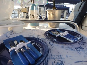 Nautical table setting on a sailboat with champagne chilling.
