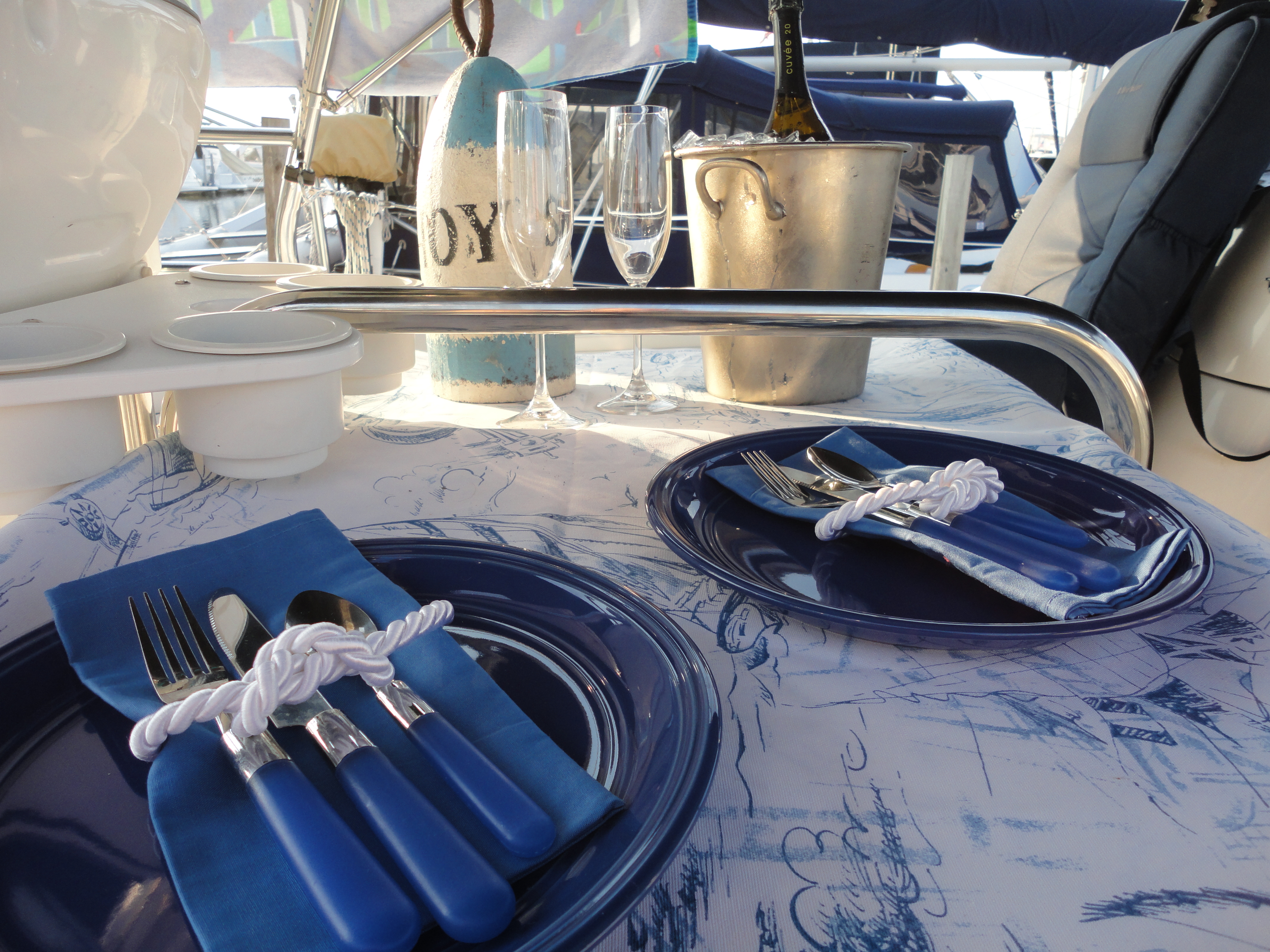 Table set for dinner on the back of the sailboat, with champagne chilling.