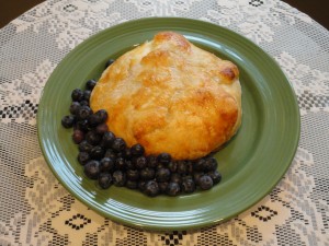 Baked Brie recipe with dried cherries inside and served with blueberries on the side