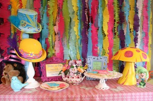 Alice in Wonderland party table with cookie display, teacups, colorful hats and mushrooms