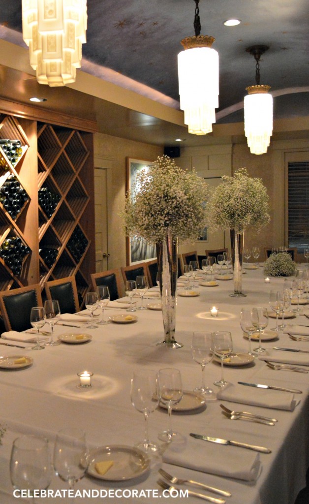 A Winter dinner party with tall silver trumpet of vases filled with baby's breath