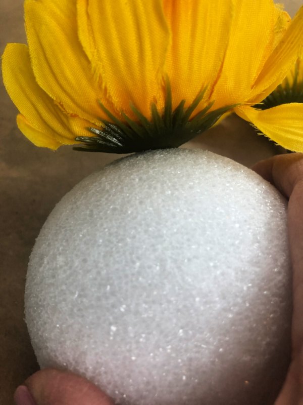 faux sunflower bloom stuck securely in a styrofoam ball