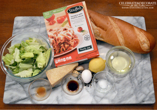 Stouffer's frozen lasagna and the ingredients for making a homemade Caesar salad laid out on a marble cutting board 