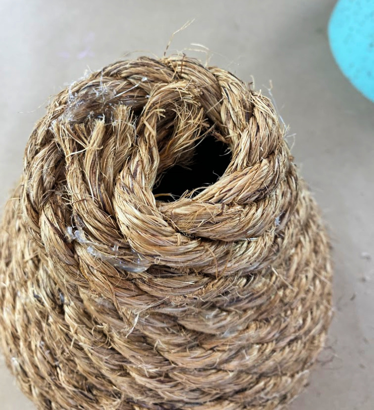Looking at the top of a diy jute bee skep with a hole in the top of it