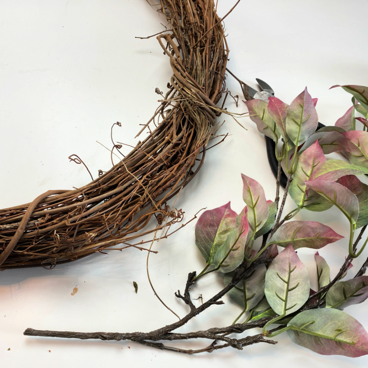 Faux fall leaves and a grapevine wreath form