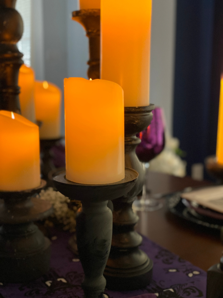 Black wooden candlesticks with faux candles on them that are glowing. 