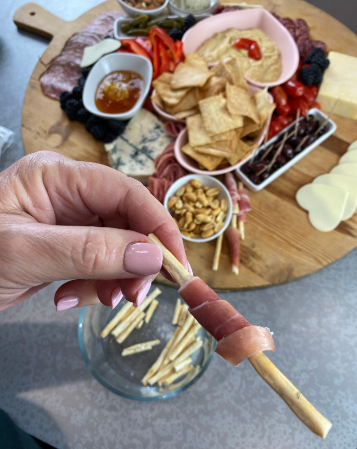 Wrapping prosciutto around a breadstick 
