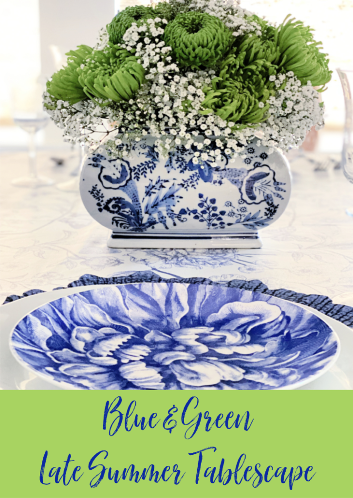Blue peony salad plate on white china and blue starburst charger.  Green chrysanthemums and babies breath in a chinoiserie cachepot 
