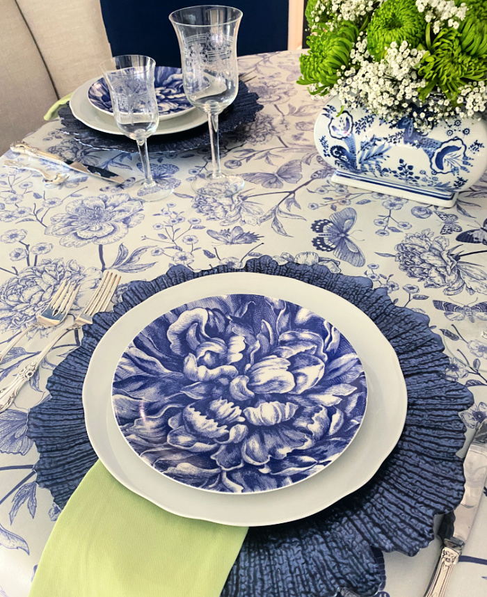Blue and white tablescape with blue and white floral print tablecloth and elegant blue and white plate stack
