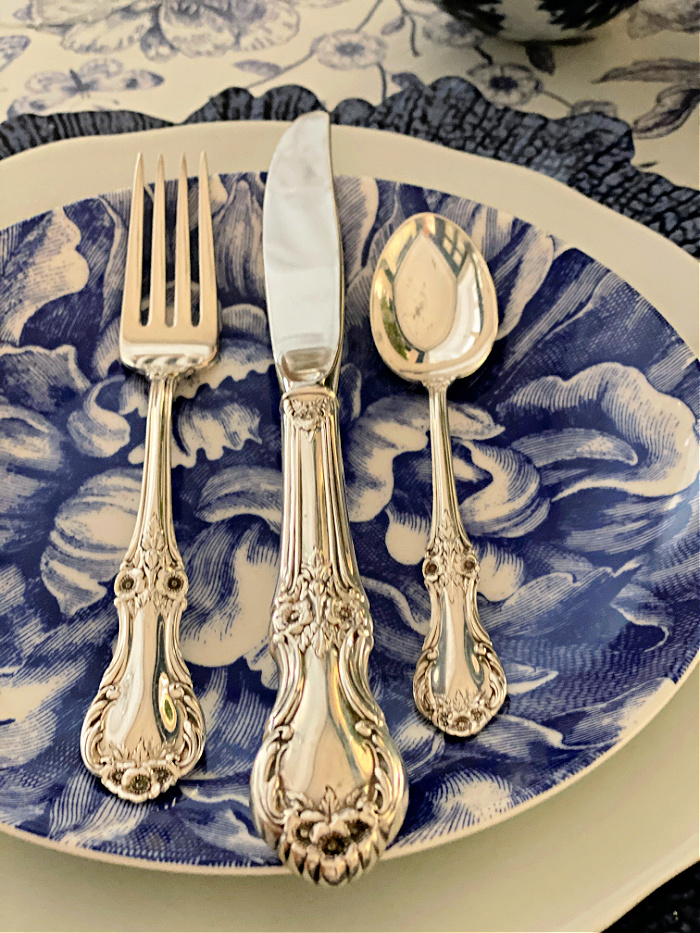 Blue peony salad plate with sterling silver flatware displayed on it.