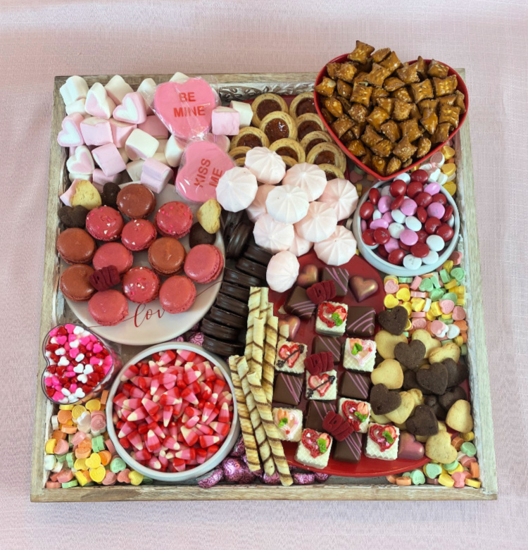 Desserts and candies and mini pretzels on a Valentine's grazing board