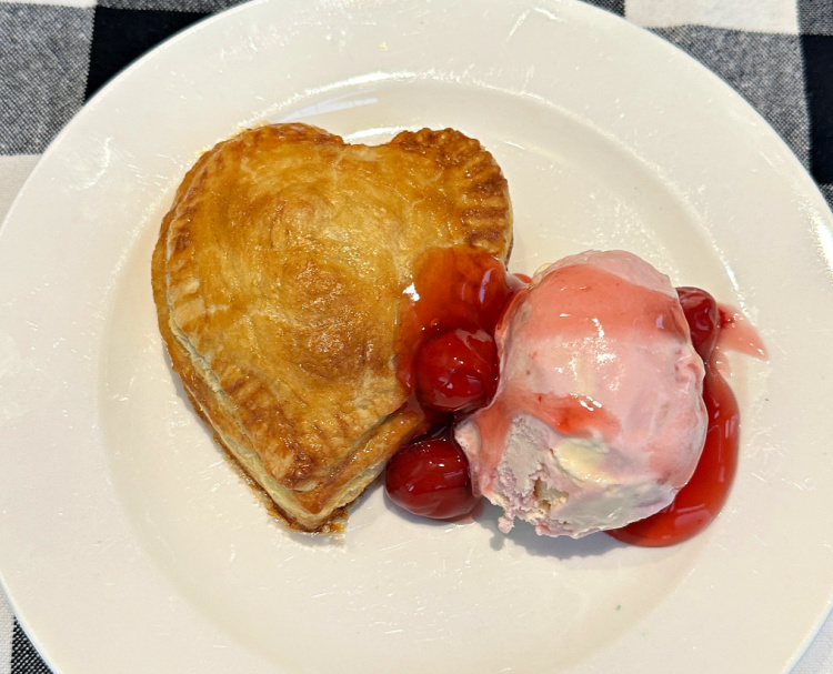 Heart shaped cherry pie with cherry topping and cherry ice cream