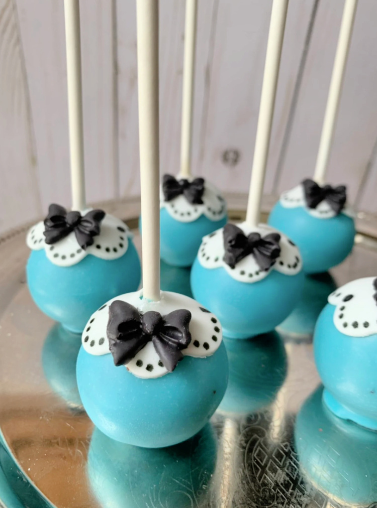 Alice in wonderland themed cake pops in blue with white collar and black bows