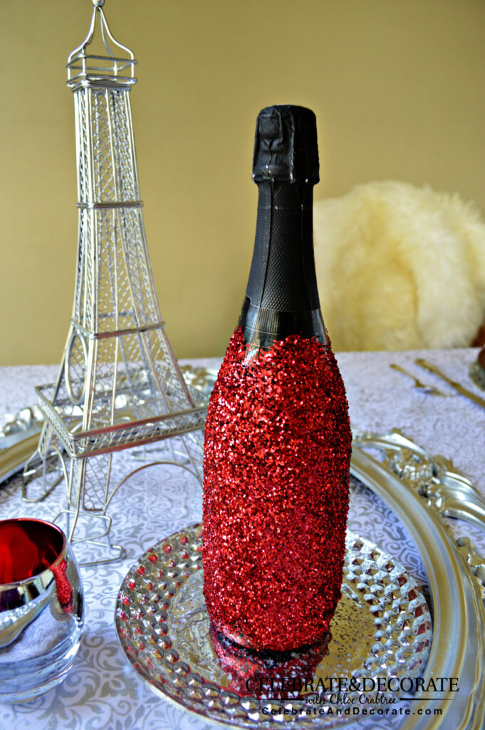 A champagne bottle covered with red glitter 