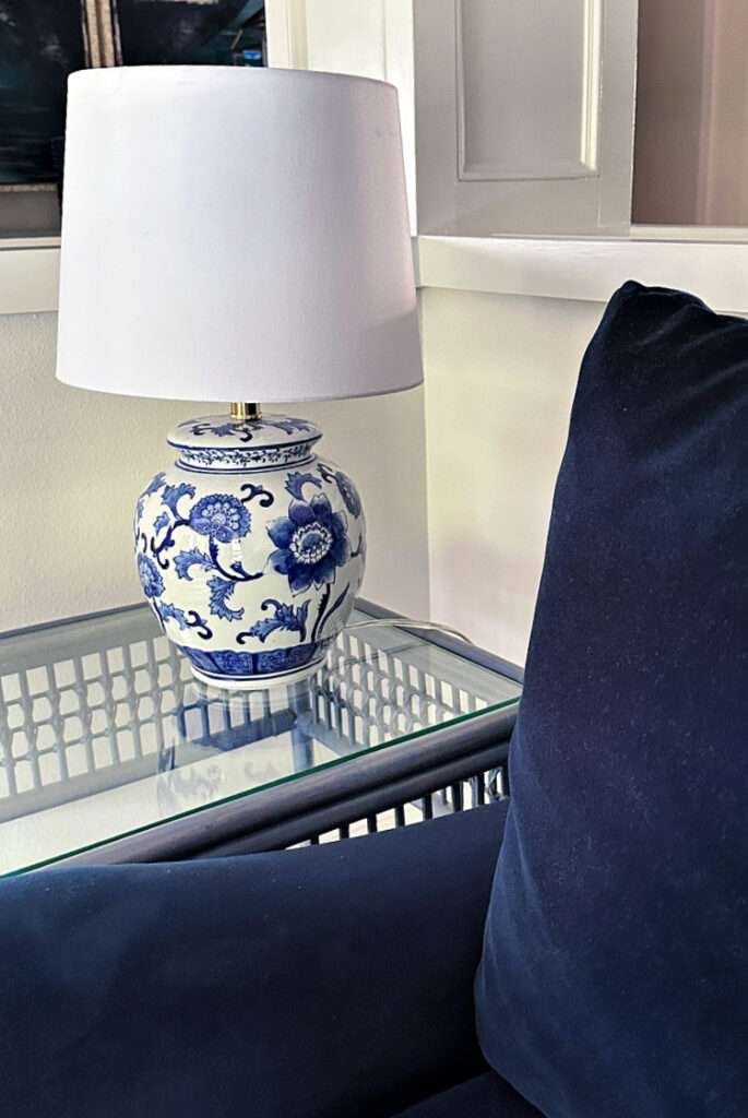 A blue and white chinoiserie lamp on a wicker table.