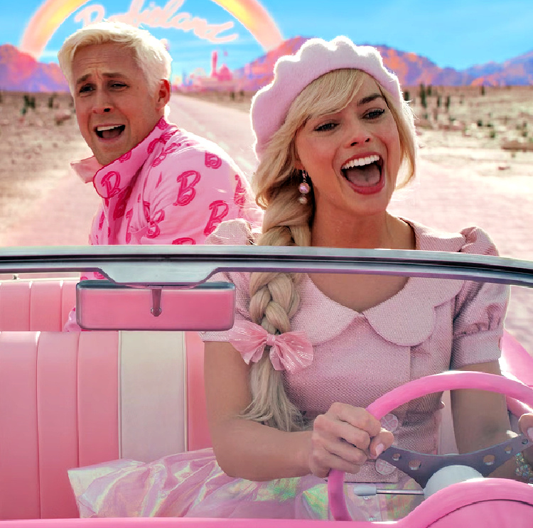 Photo of Barbie and Ken in a pink and white car driving through the desert.